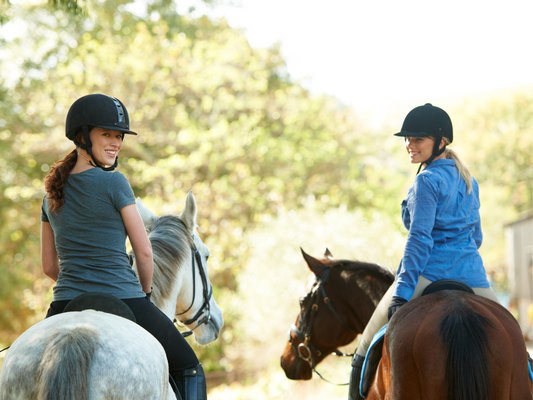 Two women look over their shoulders while riding